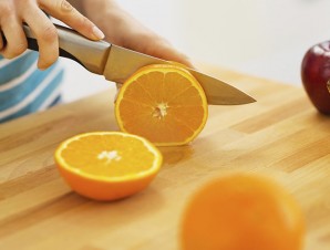 Closeup on woman cutting orange